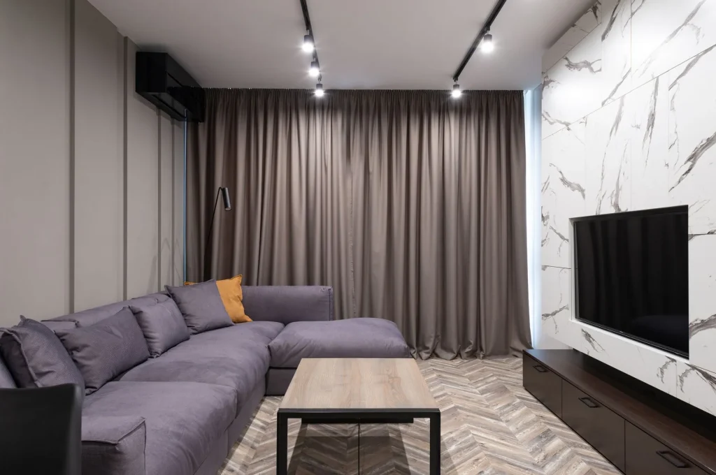 Elegant modern living room with corner sofa and minimalist decor showcasing simplicity.